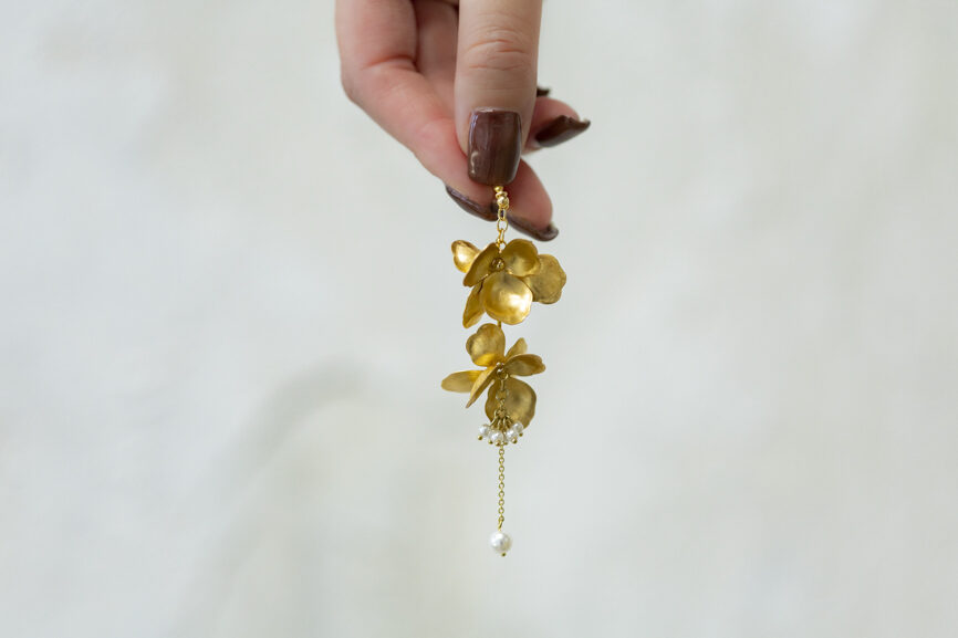 金色の耳飾りを持つ手